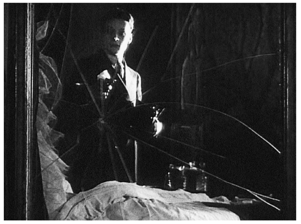 still from Jean Epstein's "Six et demi onze" - the character is holding a camera, and has shattered the mirror with a gunshot