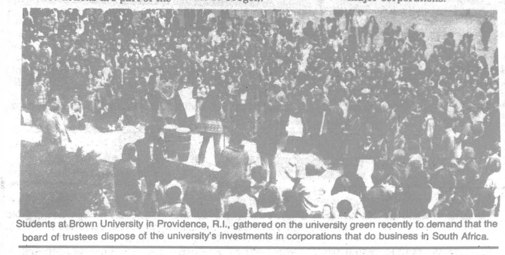 newspaper photograph of Brown students "gathered on the university green ... to demand that the board of trustees dispose of the university's investments in corporations that do business in South Africa