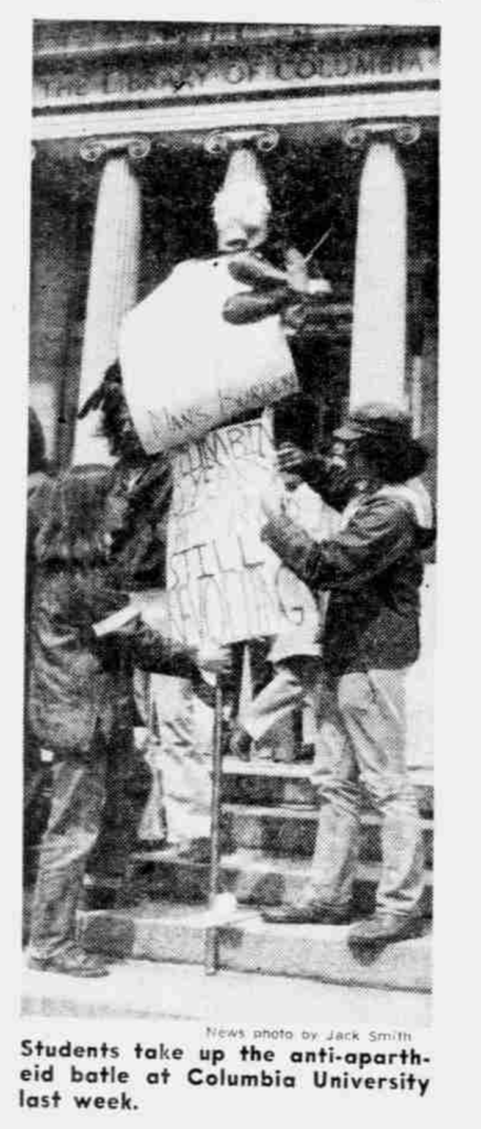 newspaper photograph of students on Low Library steps with protest signs, caption reads "Students take up the anti-apartheid battle at Columbia University"