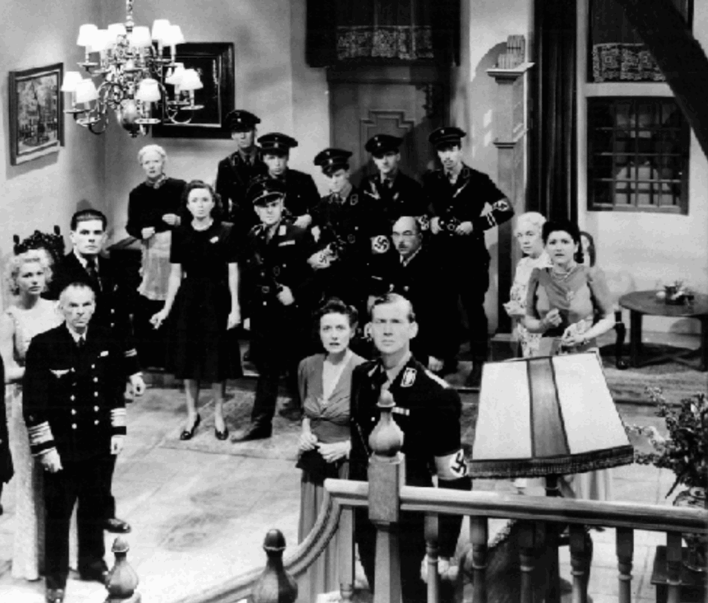 still from The Silver Fleet. a party of Nazis in Van Leyden's house, on the night before his plan comes to fruition. he has just proven himself for the final time to the Nazis, and his wife looks stone hard at him.